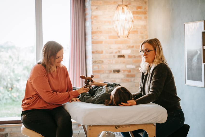 mor sidder ved barn til behandling for selvstimulering